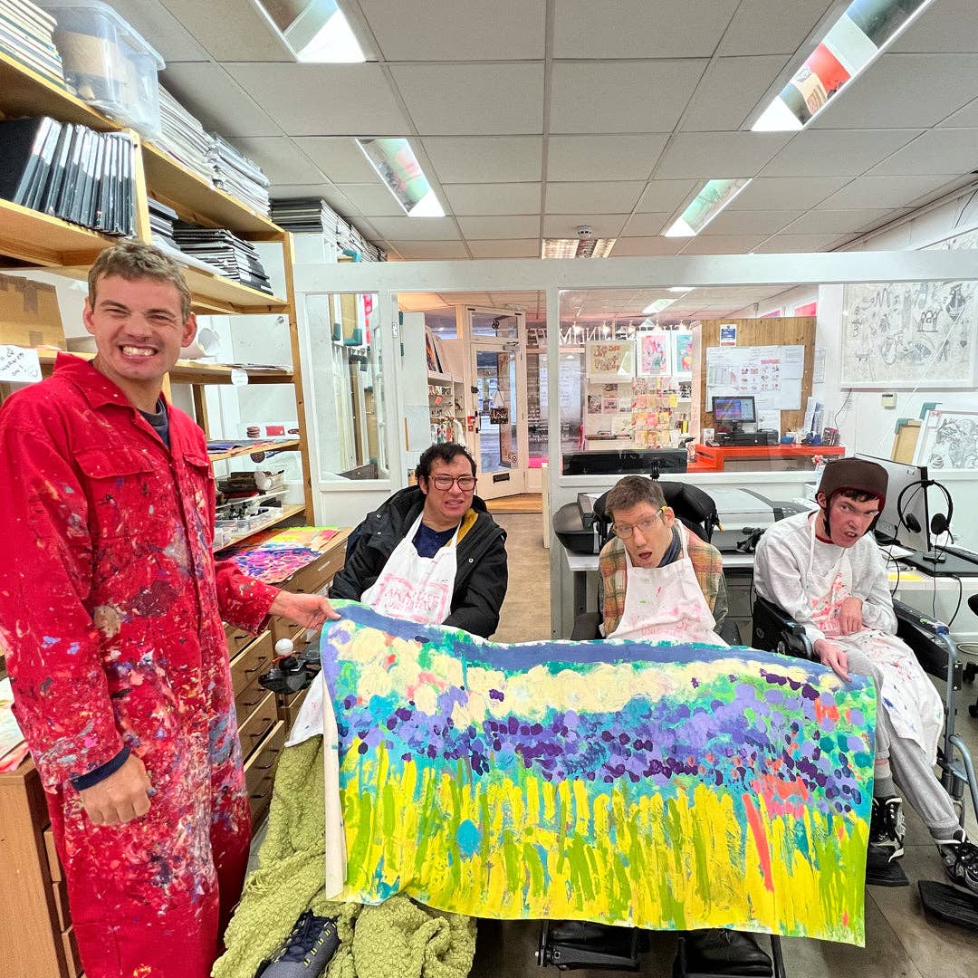Group of people in a classroom setting with a colorful painting