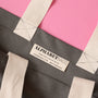 Gray tote bag with 'Alphabet Bags' label on a pink background