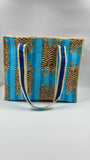Blue and gold patterned bag with a strap on a gray background