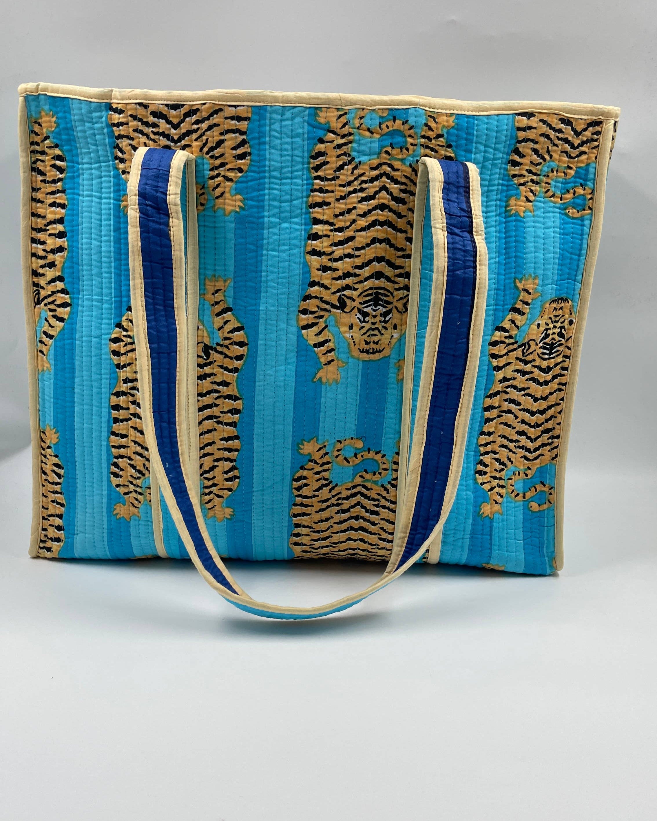 Blue and gold patterned bag with a strap on a gray background