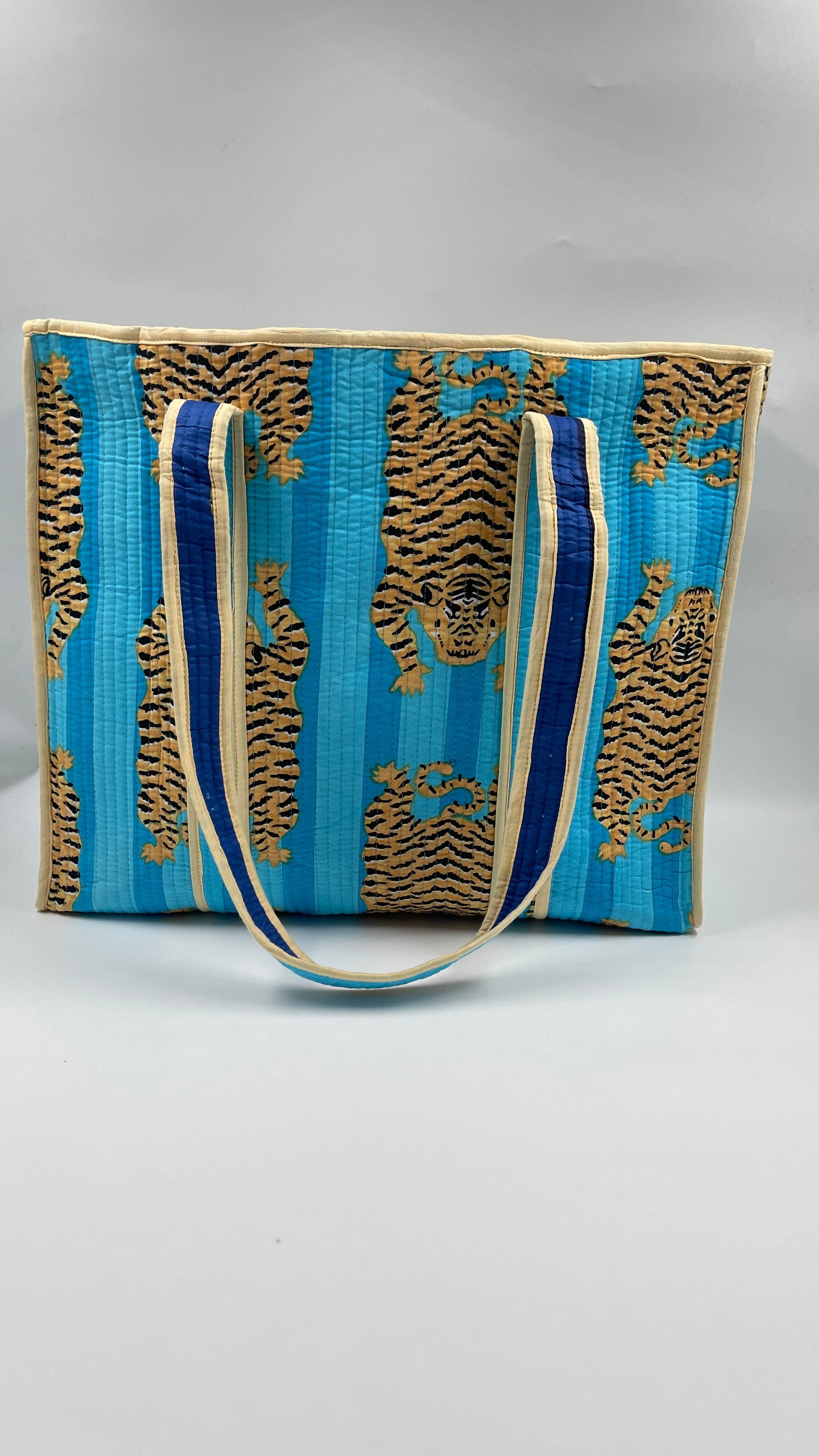 Blue and gold patterned bag with a strap on a gray background