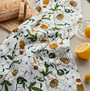 Floral-patterned cloth with lemons and bread on a table