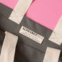 Gray tote bag with 'Alphabet Bags' label on a pink background