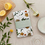 Floral-patterned tea towel on a table with lemons and flowers
