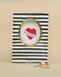 Card with striped border, heart design, and 'KEEPER' text on a beige background