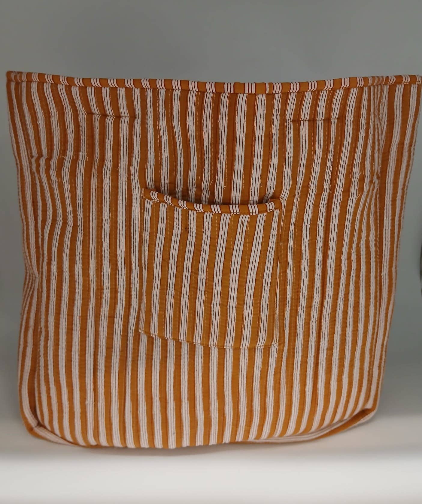 Striped bag with a pocket on a gray background