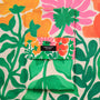Floral patterned tea towel with a brand label on a matching fabric background