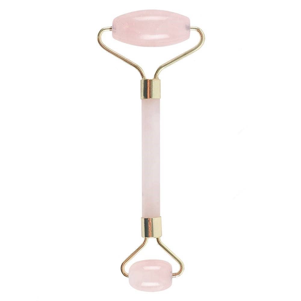 Pink facial roller with gold accents on a white background
