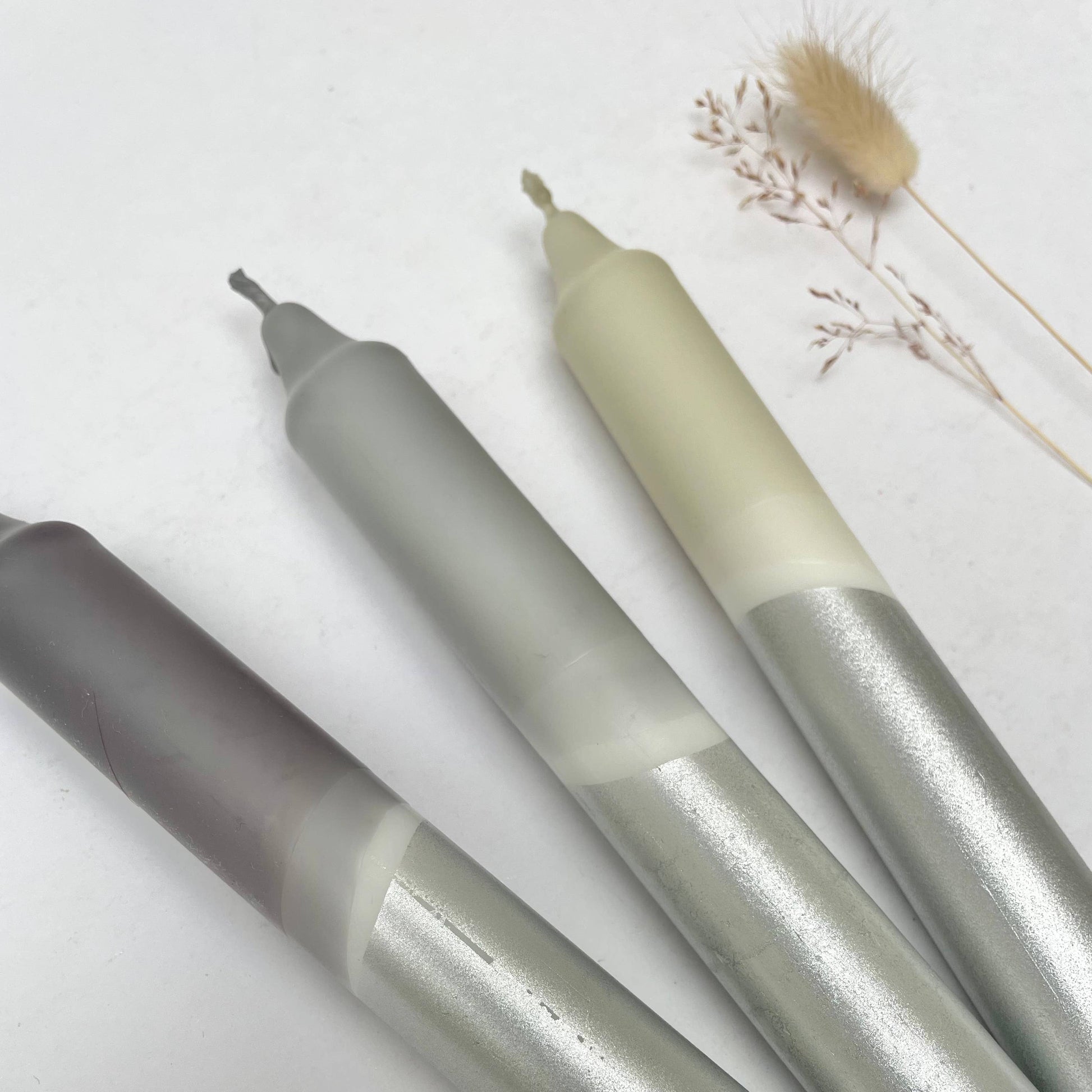 Three metallic pens with gradient colors on a white background