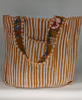 Striped tote bag with floral accents on a plain background