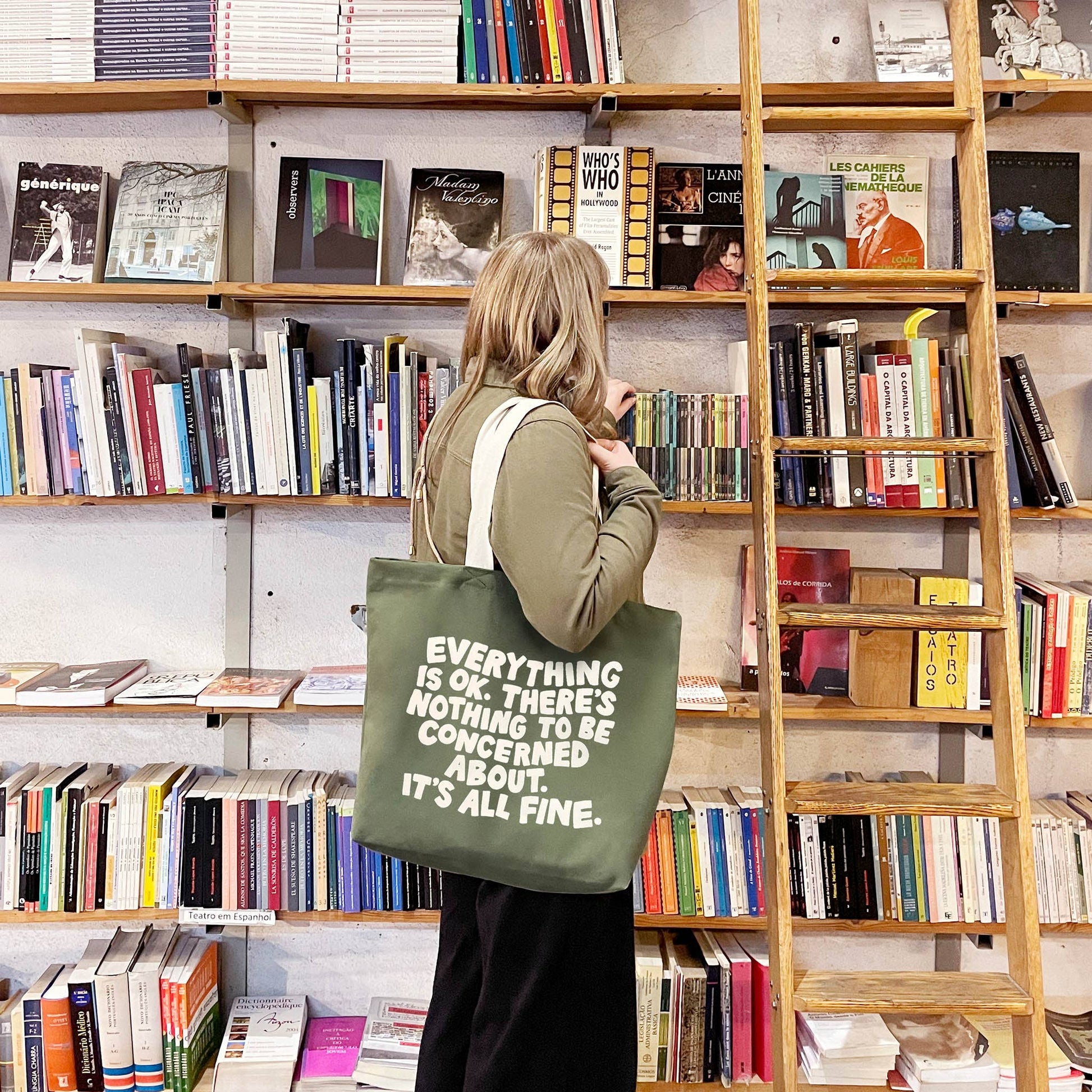 Person holding a tote bag with a message in a bookstore