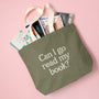 Green tote bag with 'Can I go read my book?' text, filled with books on a pink background