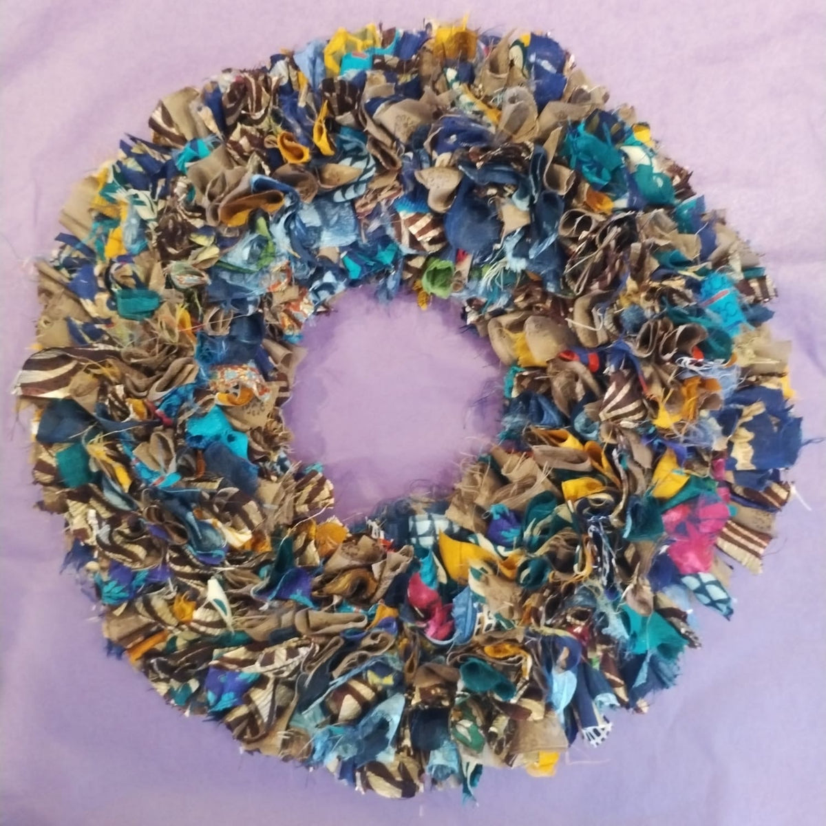 Multicolored fabric wreath on a purple background