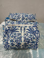 Set of three blue floral-patterned pouches on a reflective surface with a neutral background