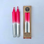 Two pink and silver candles with a cardboard packaging box on a white background