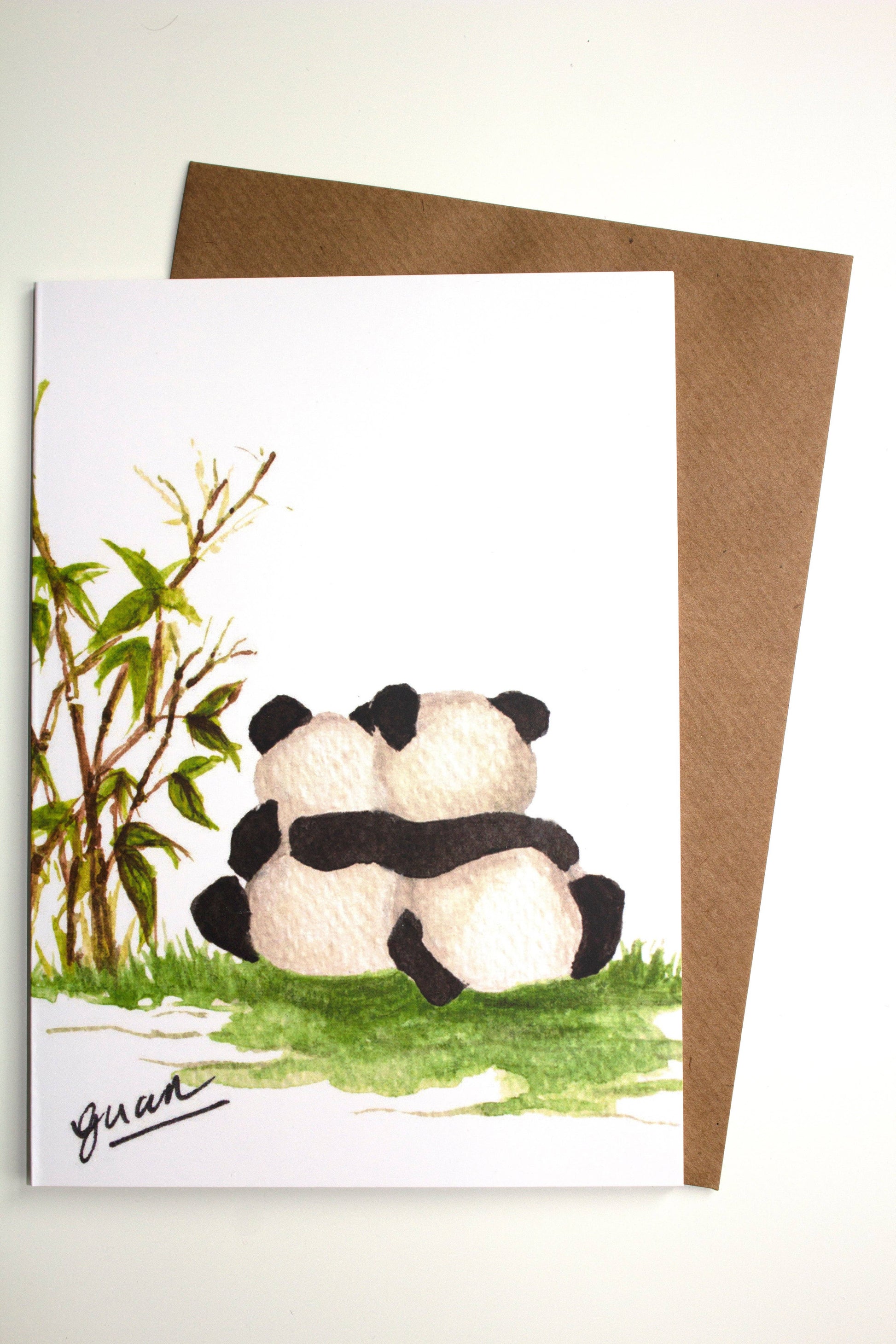 Greeting card with two pandas hugging and a tree, on a white background