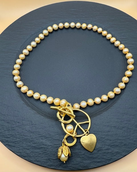Golden Hue Longer Peasrl Necklace With Gold Charms