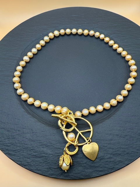 Golden Hue Longer Peasrl Necklace With Gold Charms