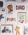 Collection of Father's Day cards with various designs and text on a wall.