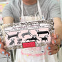 Person holding a chocolate bar with illustrations of dogs and text on the packaging.
