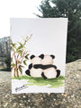 Card with two panda bears hugging and bamboo plants on a natural background