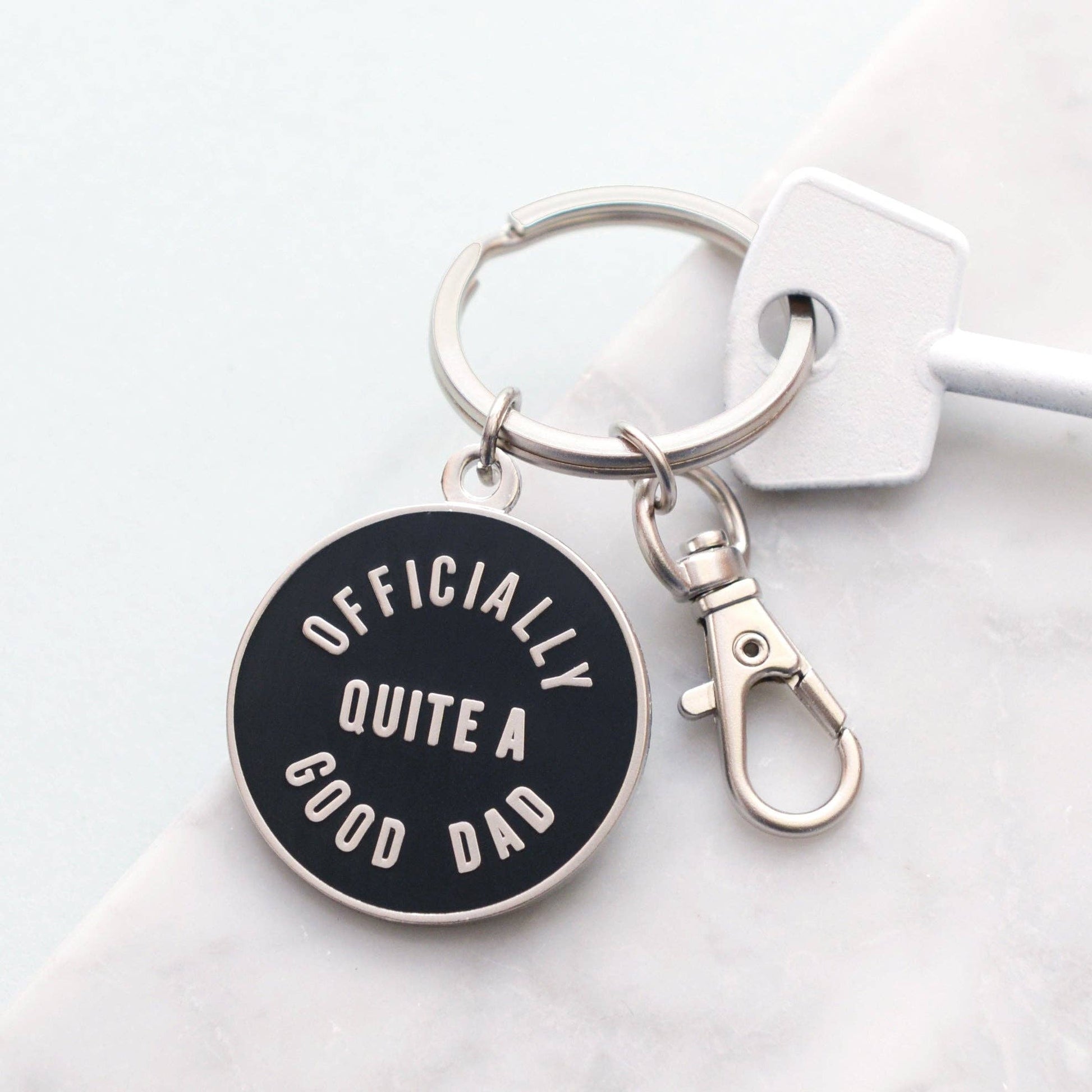 Keychain with 'Officially Quite a Good Dad' text on a white background