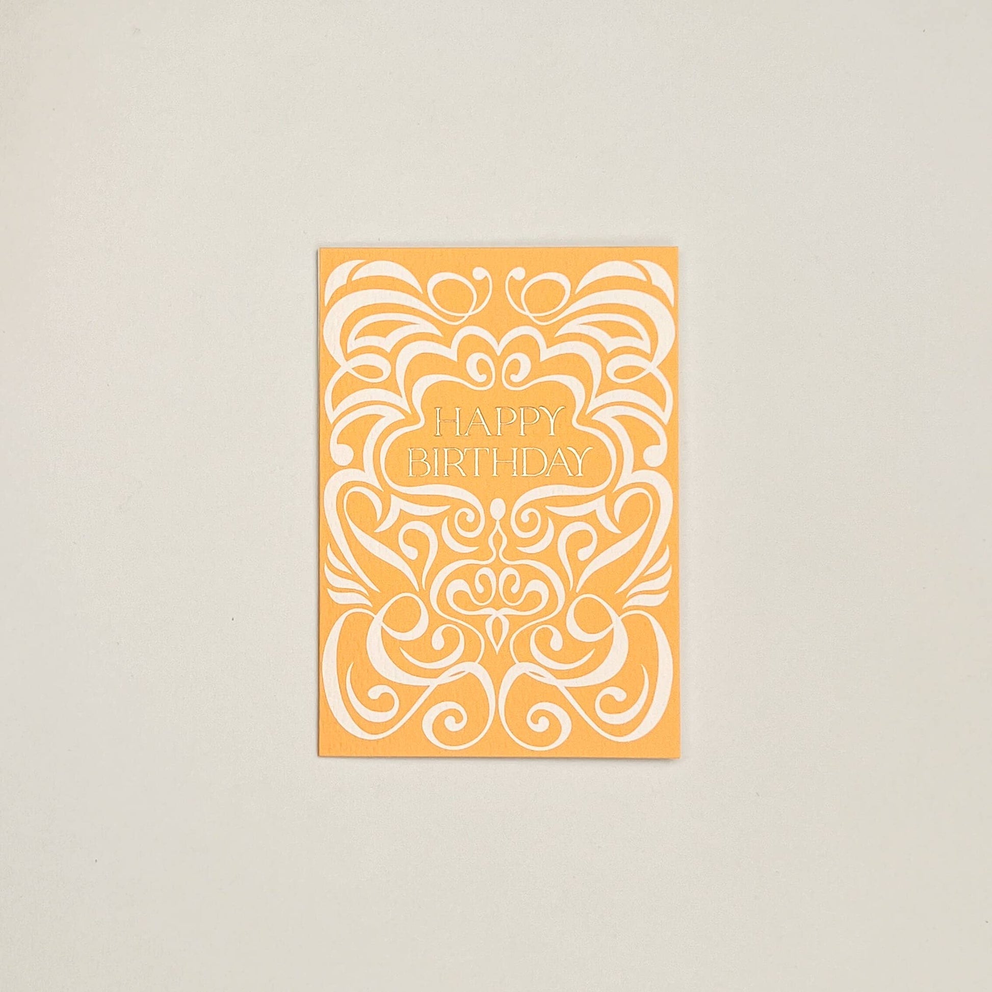 Orange birthday card with white decorative patterns on a beige background