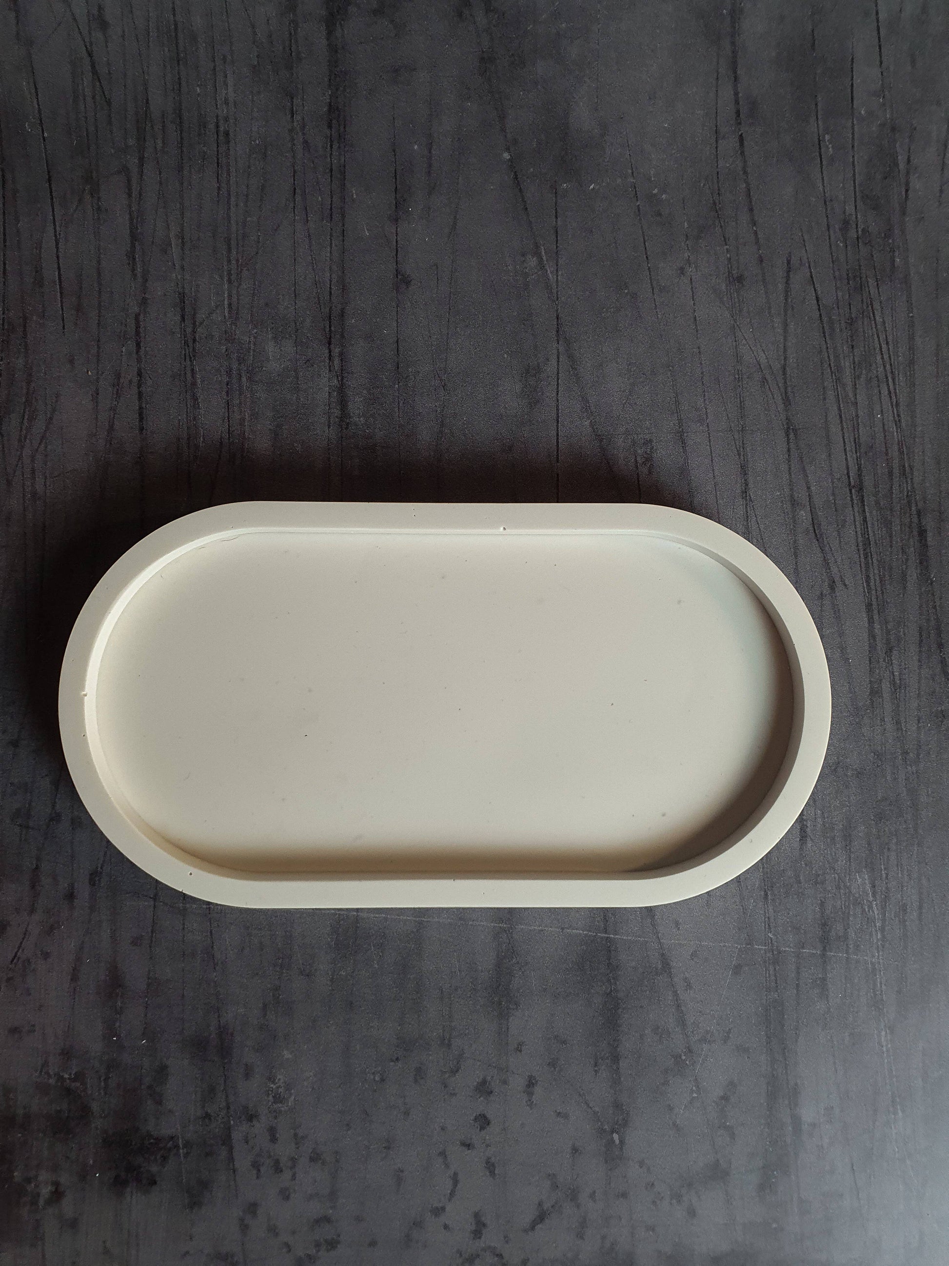 Beige ceramic tray on a dark wooden surface