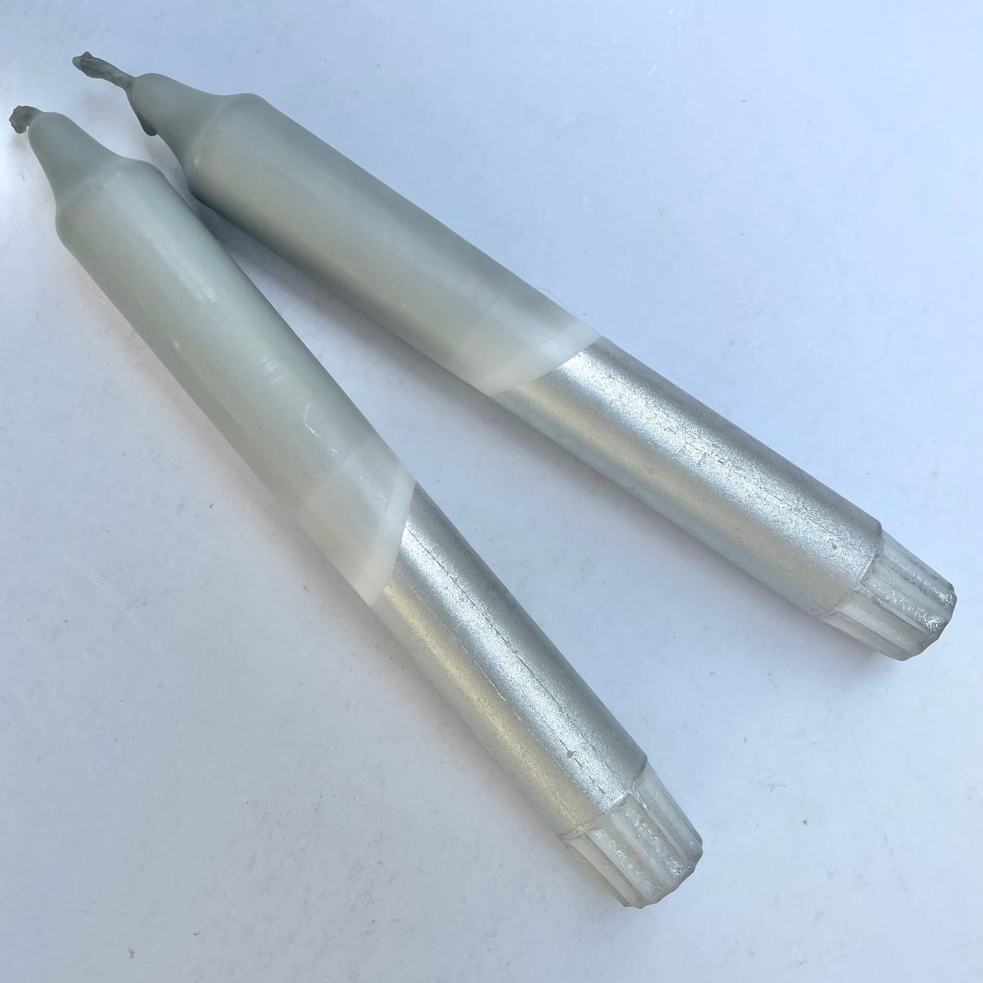Two metallic cylindrical objects on a white background