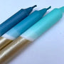 Three markers with blue, green, and gold bodies on a light blue background