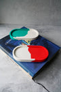 Colorful container lids on a book with a gray background