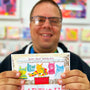 Person holding a bar of silky milk chocolate with colorful packaging featuring animal illustrations.