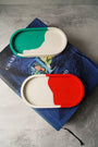 Two colorful containers on a book with a gray background