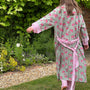 Person wearing a floral patterned robe in a garden setting