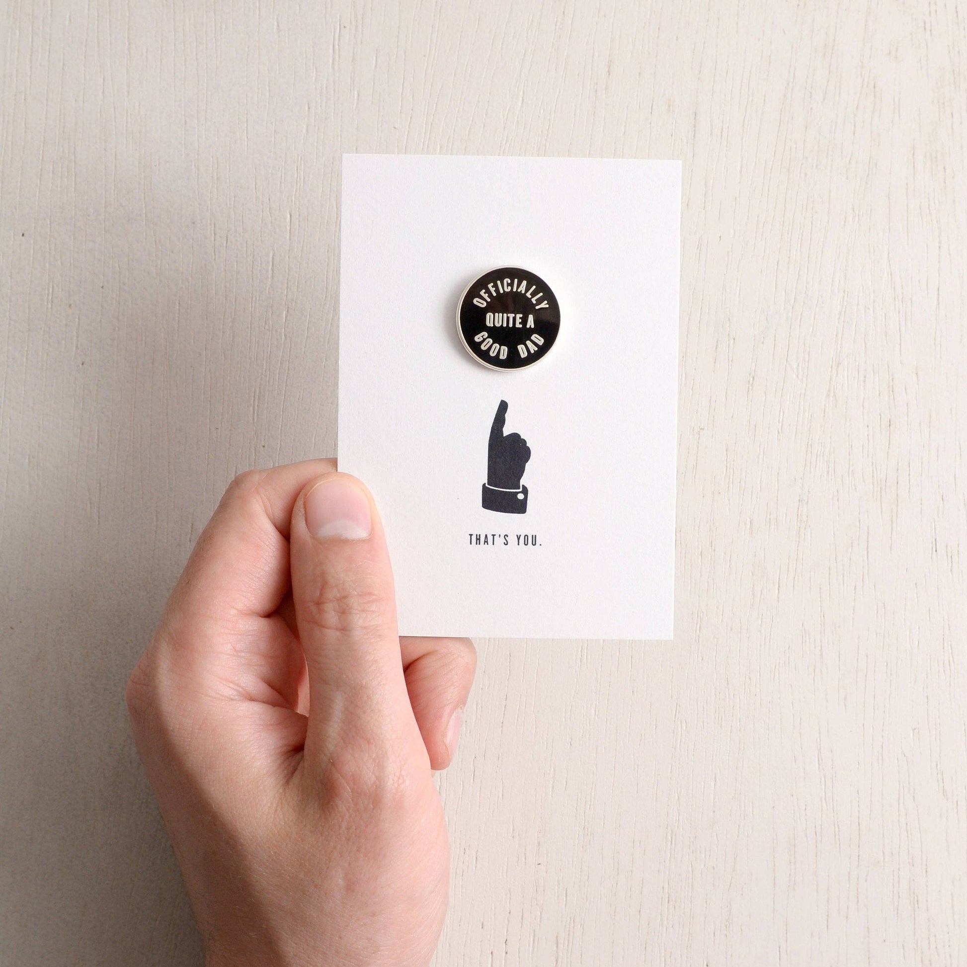 Hand holding a card with a button and text on a plain background
