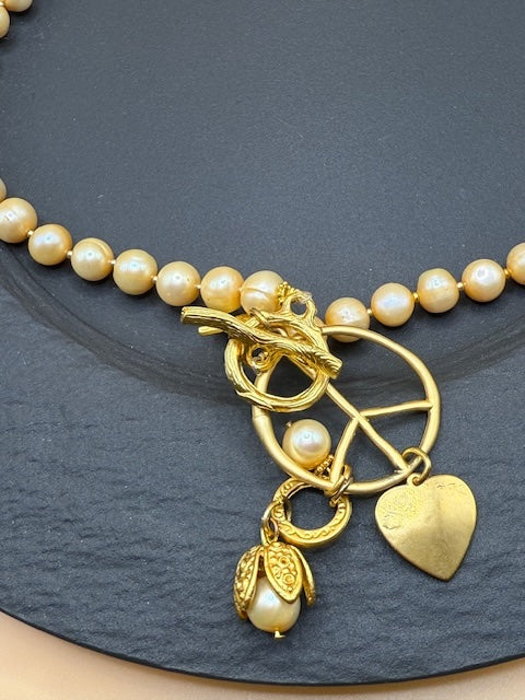 Golden Hue Longer Peasrl Necklace With Gold Charms