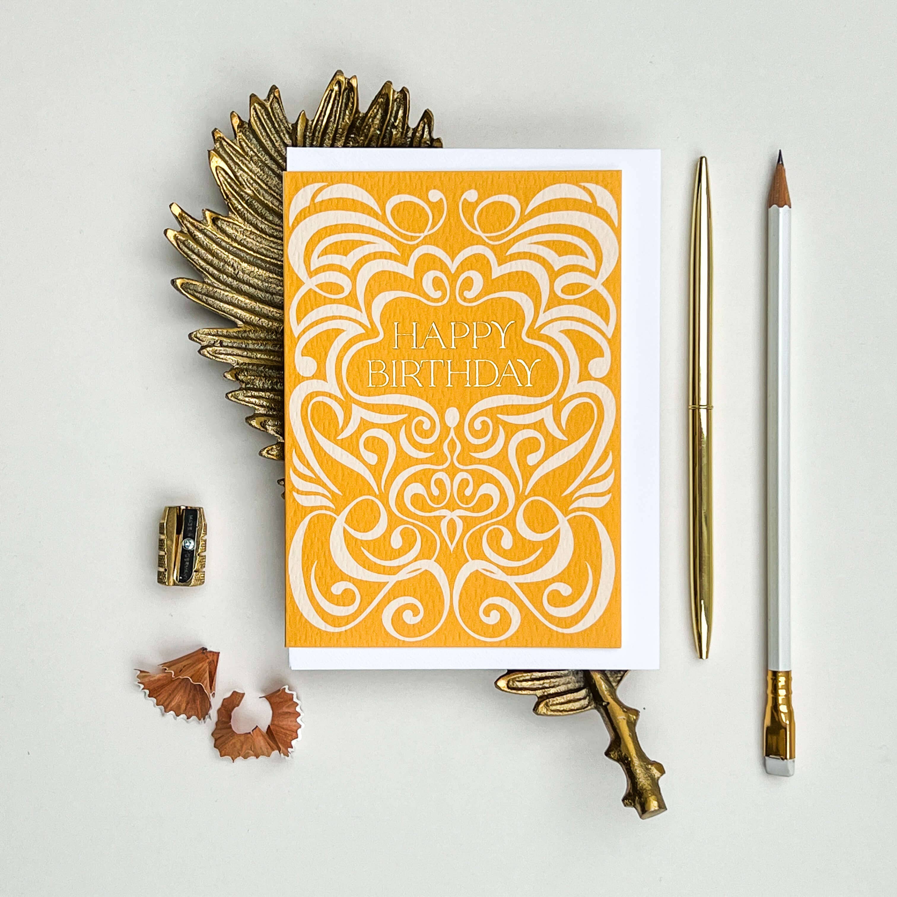 Orange and white birthday card with decorative patterns on a light gray background