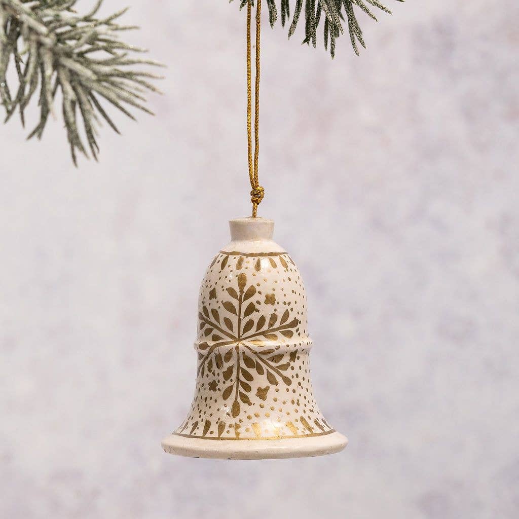 Decorative bell ornament with gold patterns hanging against a light background