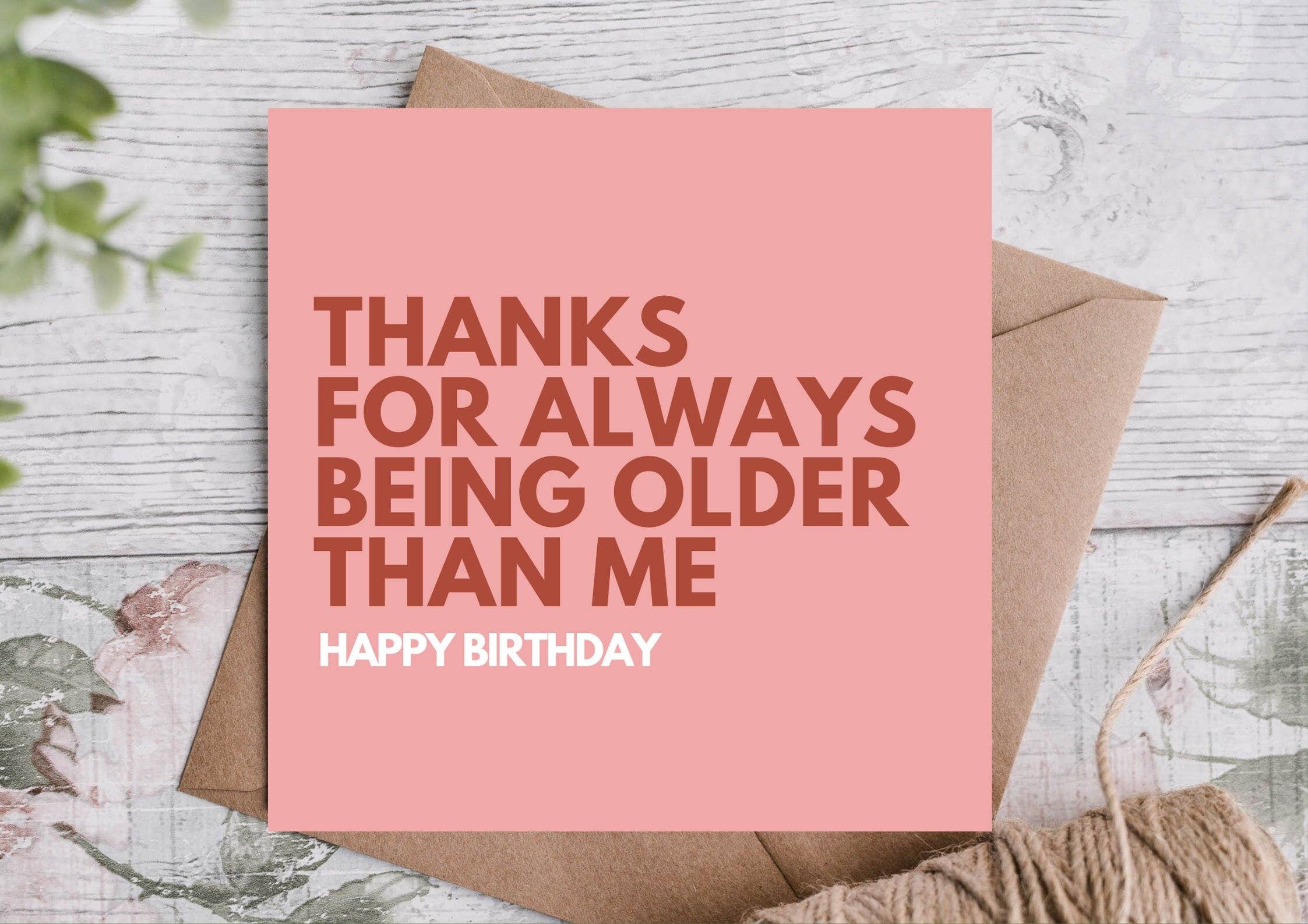Pink birthday card with text on a wooden surface