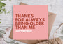 Pink birthday card with text on a wooden surface