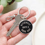Keychain with a tag reading 'Officially Quite a Good Dad' held in a hand.