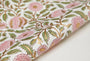 Floral patterned fabric with pink flowers and green leaves on a white background
