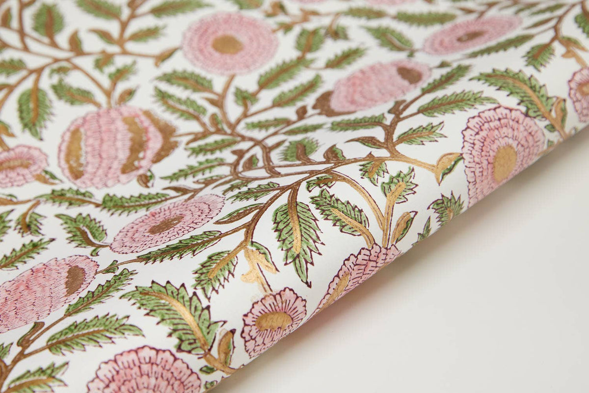 Floral patterned fabric with pink flowers and green leaves on a white background