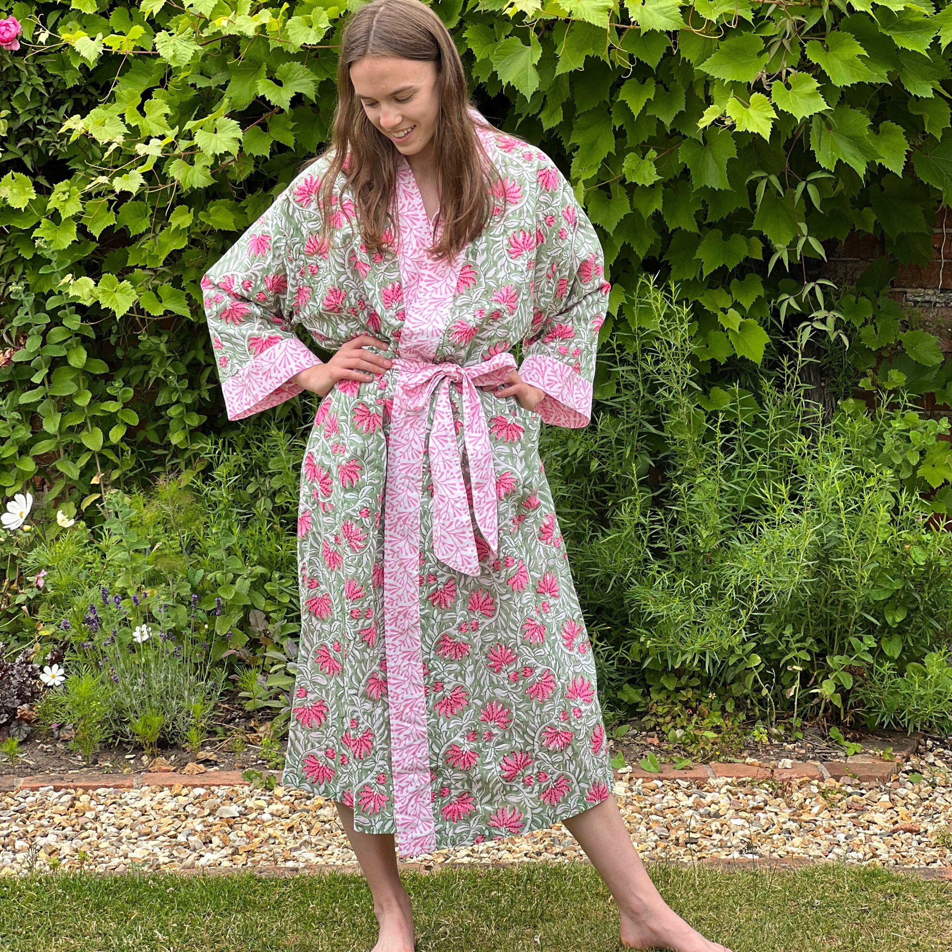 Woman wearing a floral robe standing in a garden