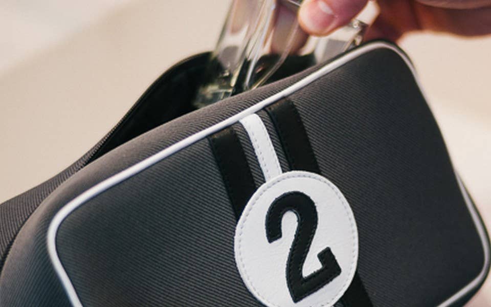 Black bag with a white number '21' patch, held by a hand.