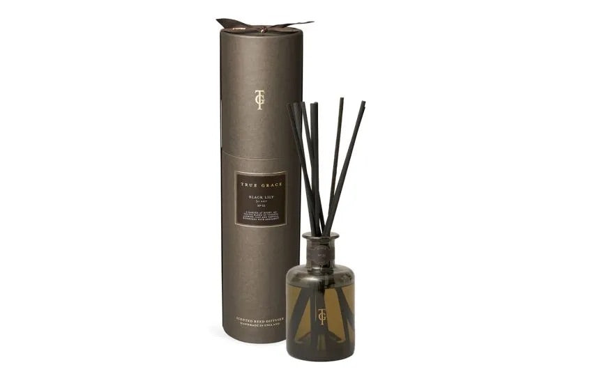 Reed diffuser set with cylindrical container and bottle on a white background