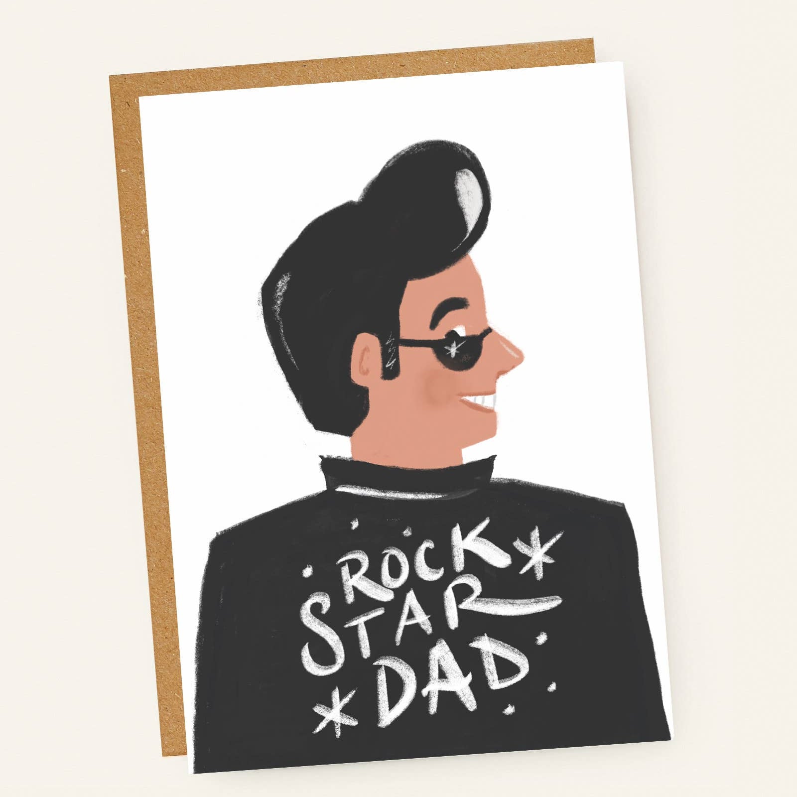 Greeting card with illustration of a person wearing sunglasses and 'Rock Star Dad' shirt on a beige background