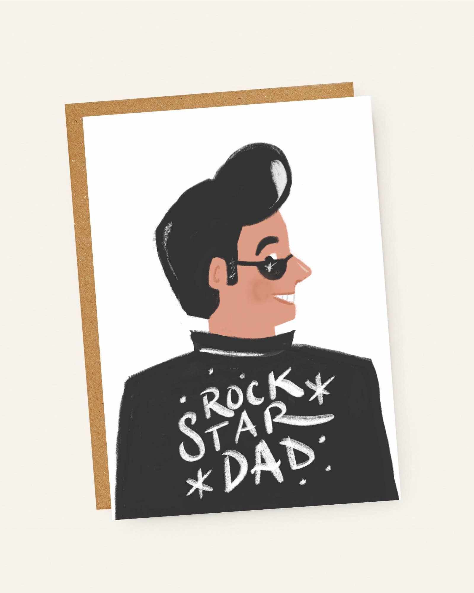 Greeting card with illustration of a person wearing sunglasses and 'Rock Star Dad' shirt on a beige background