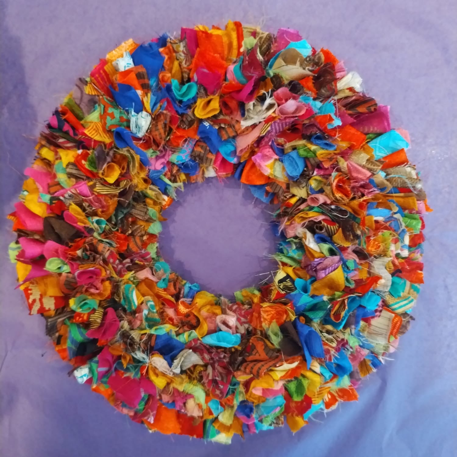 Colorful fabric wreath on a purple background