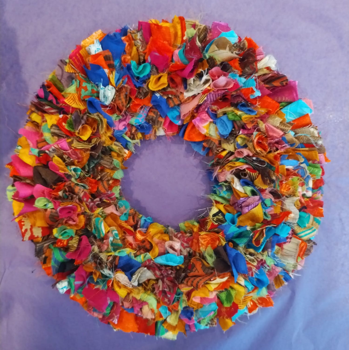 Colorful fabric wreath on a purple background